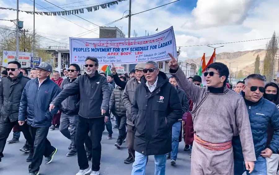 protests in Ladakh: A protester in Ladakh raises a fist, symbolizing unity and determination in the fight for environmental conservation.