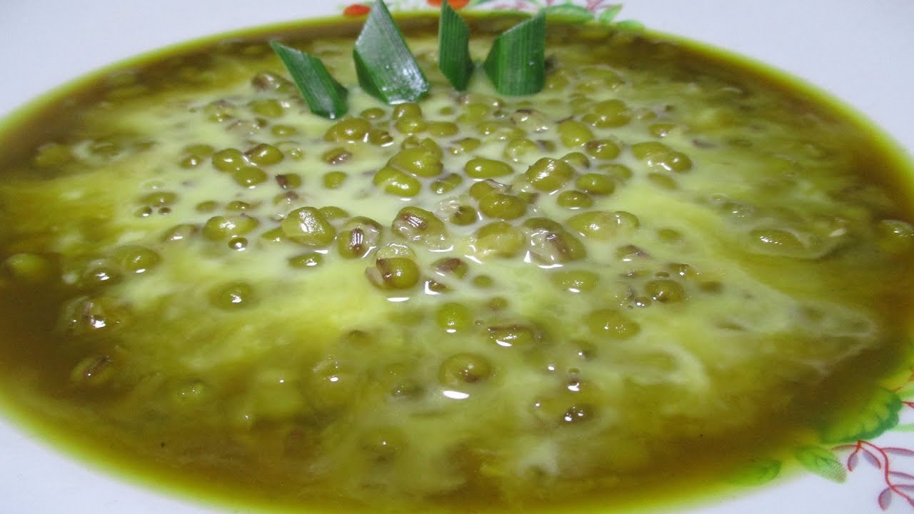 Bubur kacang hijau yang lezat disajikan dalam mangkuk tradisional dengan hiasan daun pandan.