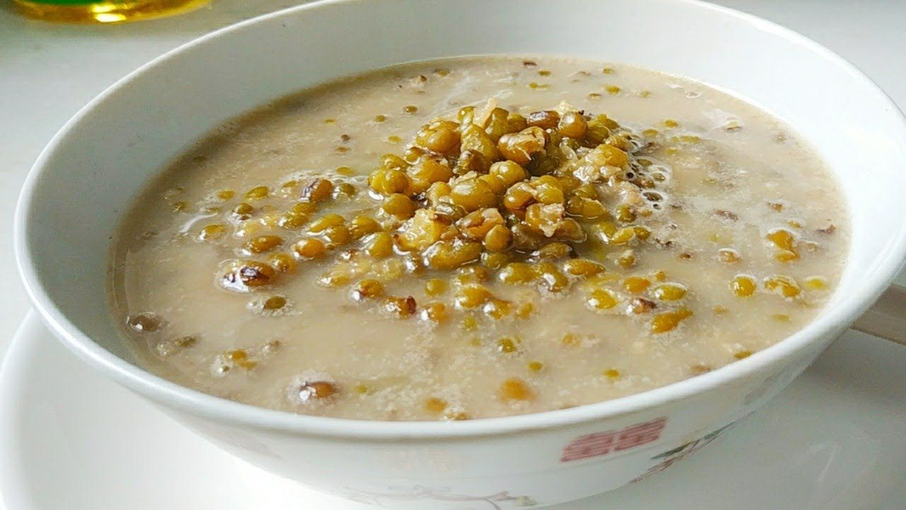 Sepiring bubur kacang hijau yang dihiasi dengan potongan ubi jalar dan taburan gula merah