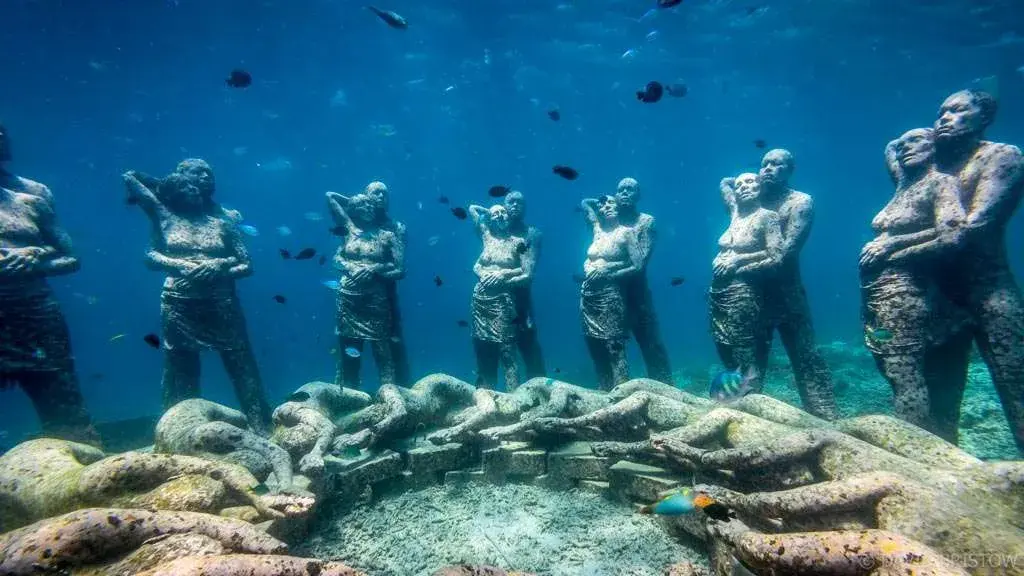 Travelers snorkeling amidst colorful coral reefs and marine life in the Gili Islands.