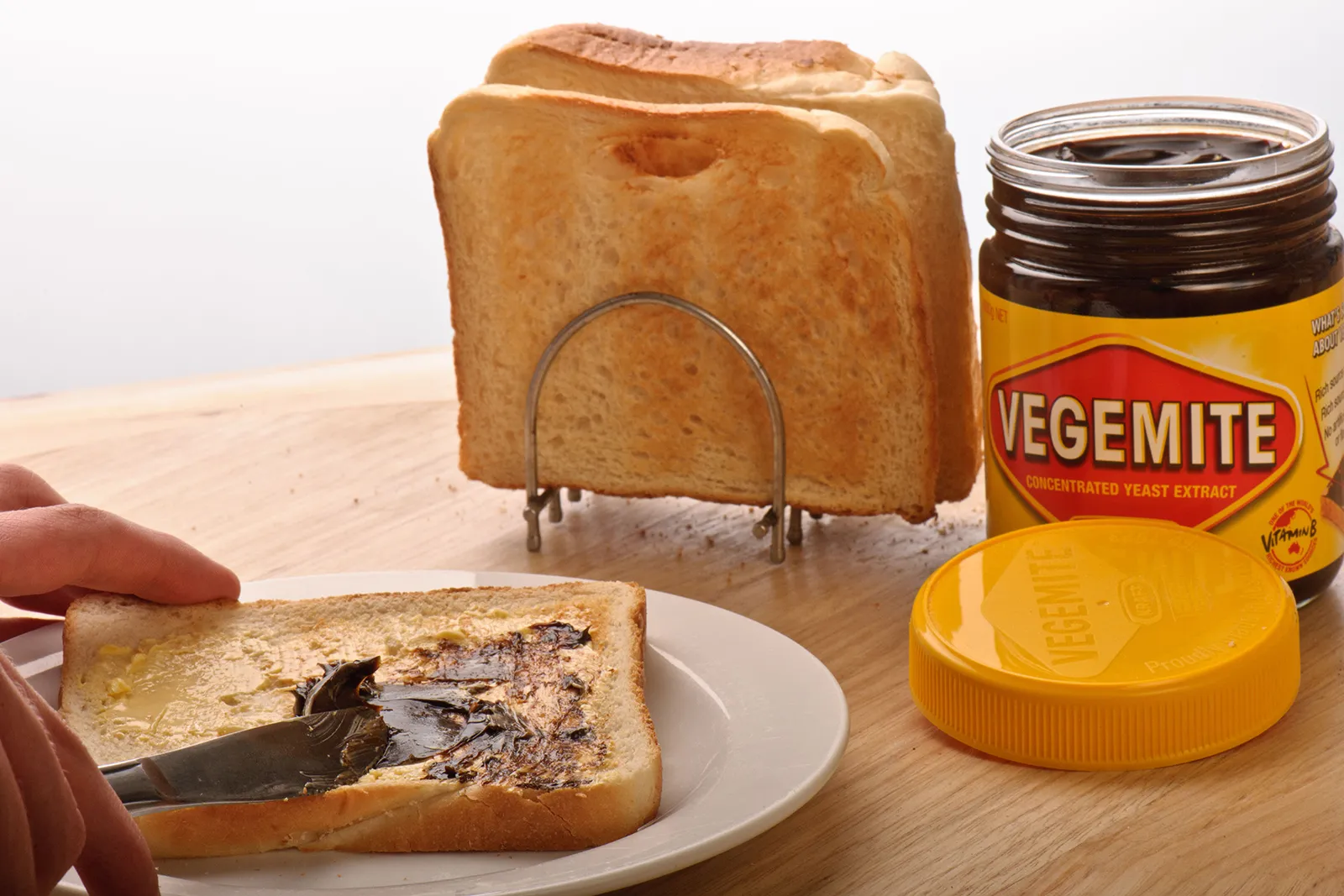 Vegemite jar with Australian flag in the background, representing its cultural significance and national pride.