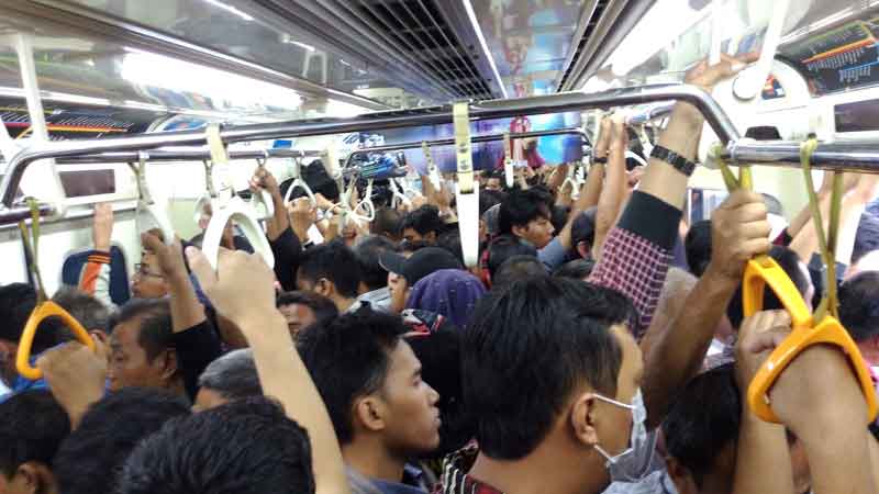 Kerumunan penumpang yang sibuk menaiki bus kota yang ramai pada waktu sibu