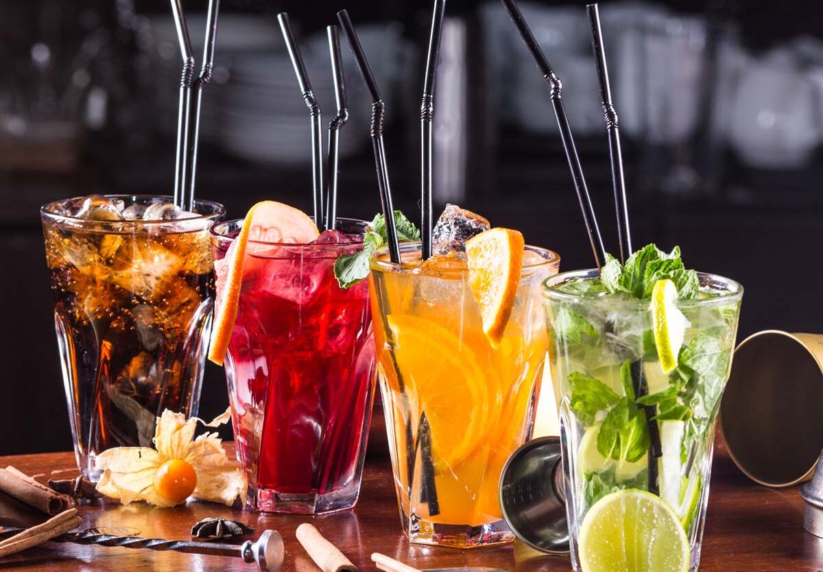 A bartender skillfully pouring a vibrant cocktail, highlighting the artistry of mixology on World Cocktail Day.