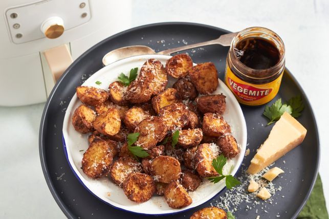 Close-up of Vegemite being spread on toast, highlighting its distinctive dark brown color and thick texture.