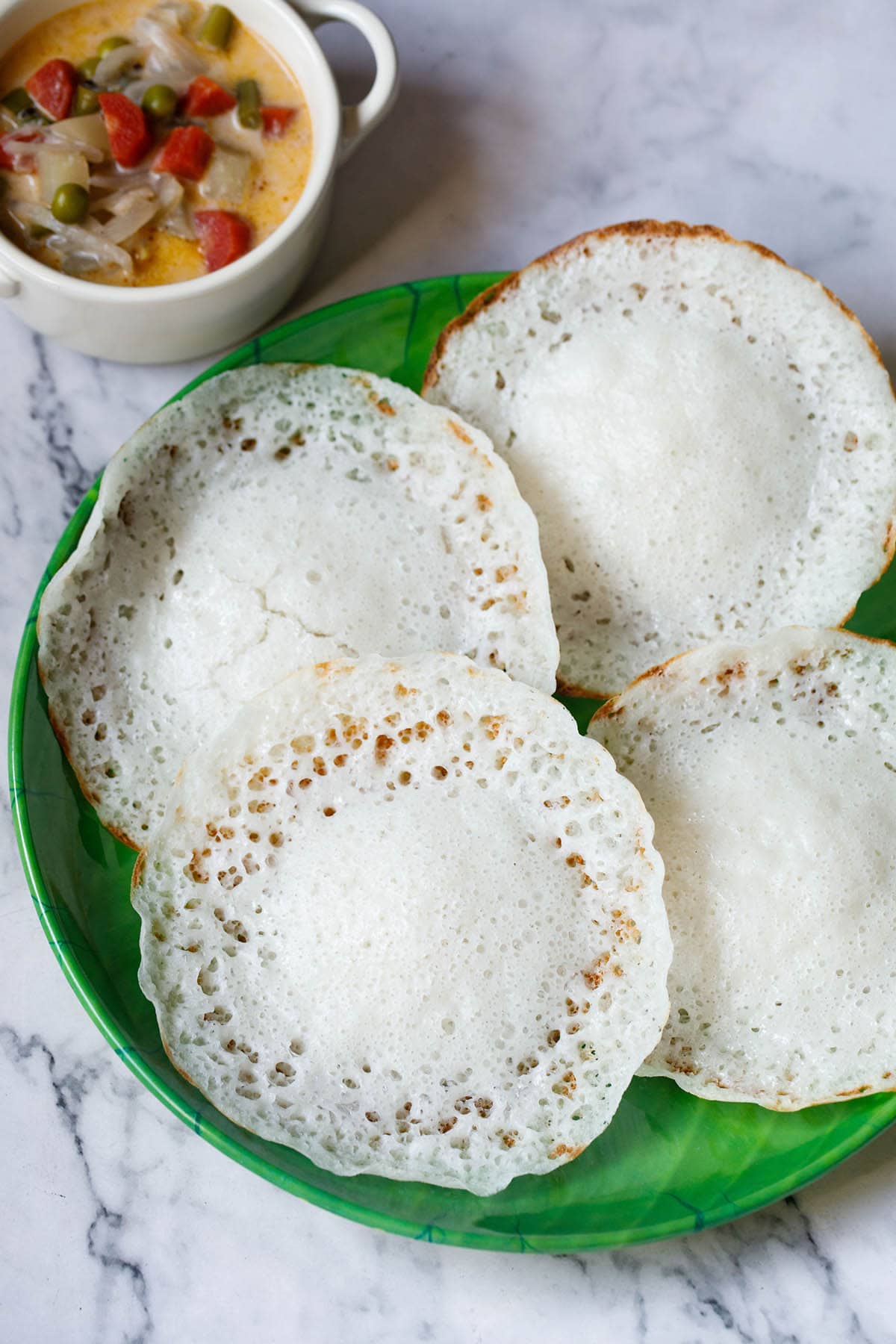 The Appam: A plate of appam accompanied by a rich, creamy vegetable stew.