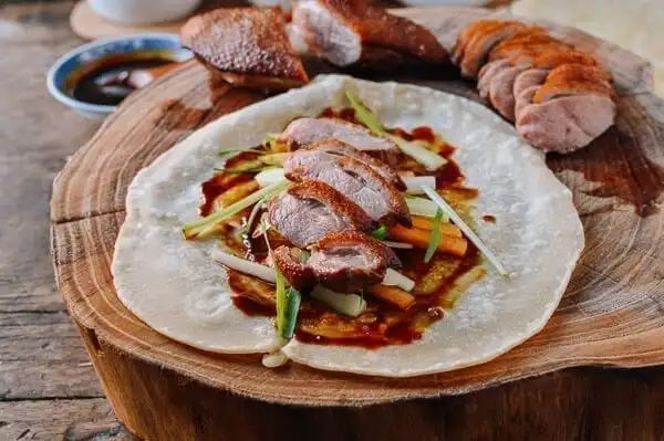 A chef expertly slicing Peking Duck at a renowned Chinese restaurant