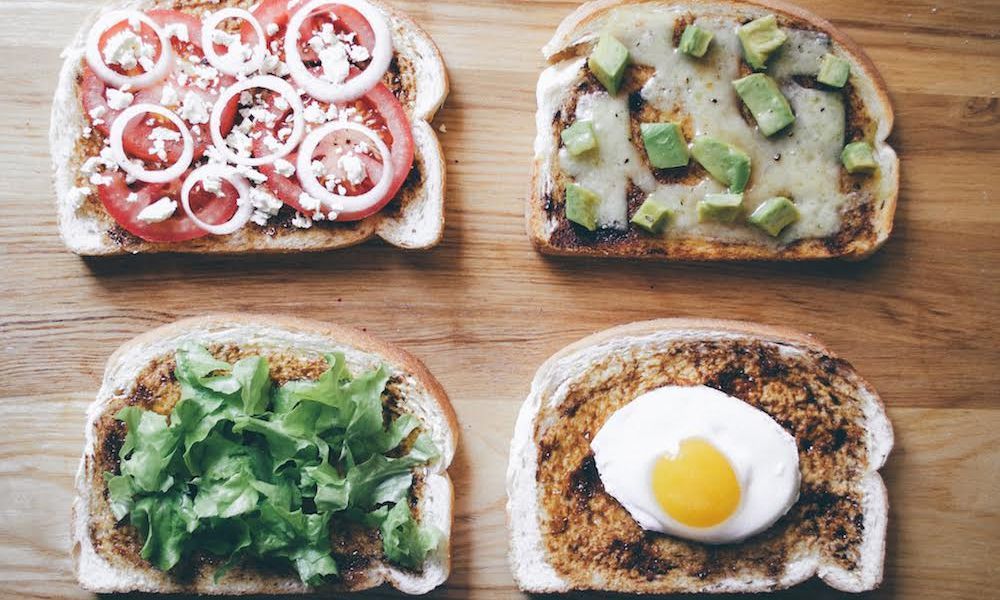  Breakfast table featuring Vegemite on toast with coffee and fresh fruit.