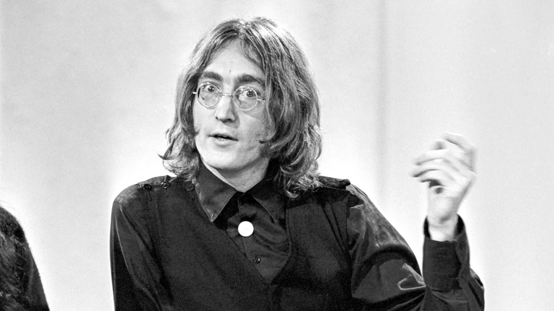 John Lennon singing passionately into a microphone 