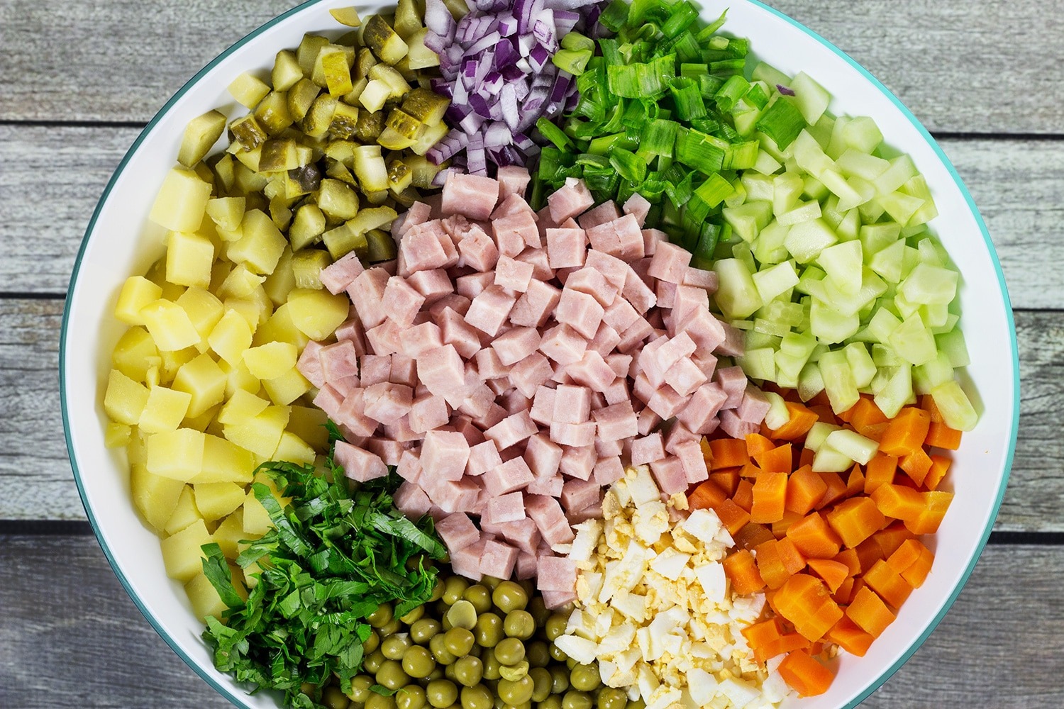 Close-up of Olivie Salad with creamy dressing and olives 