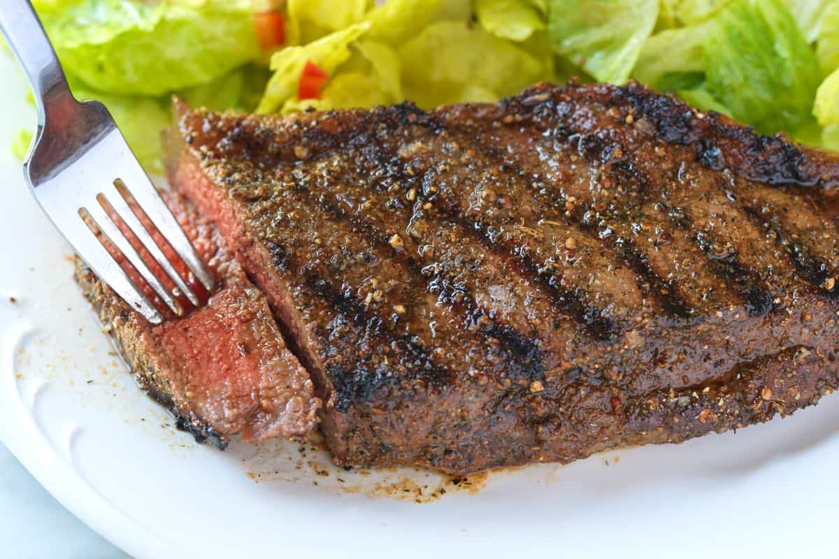 A variety of steak cuts displayed on a butcher’s table, ready for grilling. 